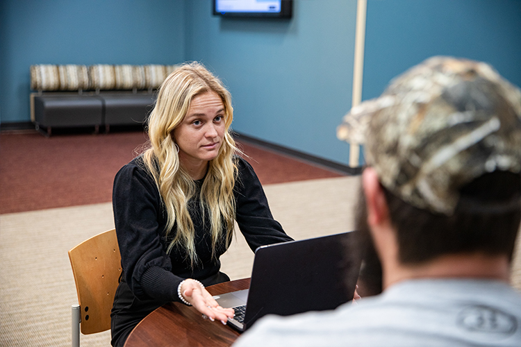 Rowan Global student Kristiina speaks to a colleague at her graduate assistantship.