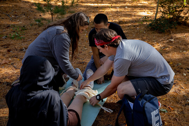Dr. Shari Willis and students in the Wilderness First Responder course treat a student during an outdoor scenario.