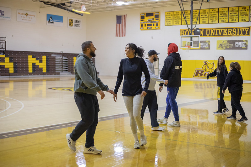 Rowan University Health and Physical Education major Adrianna can be seen on the basketball court with friends smiling inside Esby Gym.