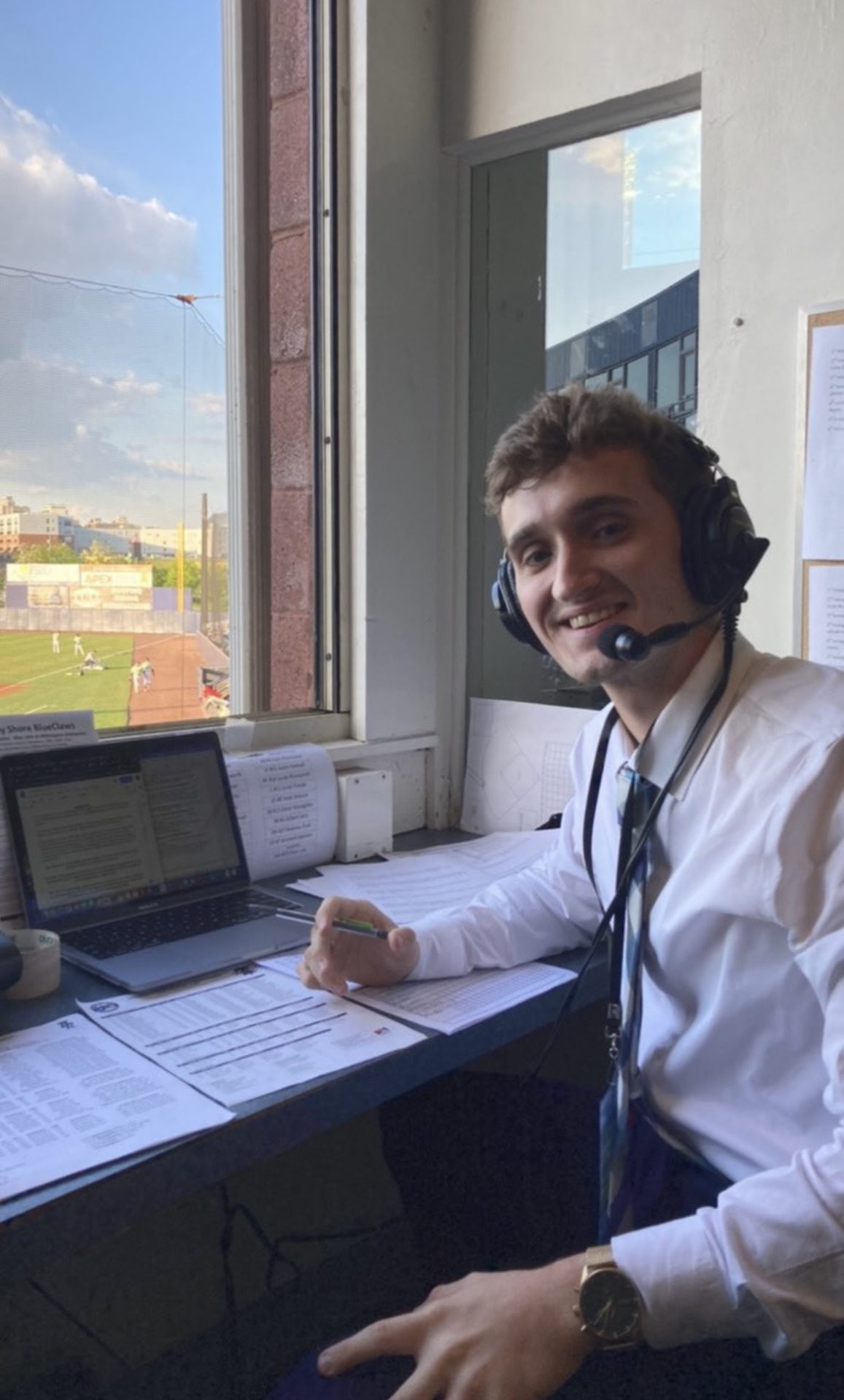 Danny Ryan wears business attire while working the booth at a baseball game.