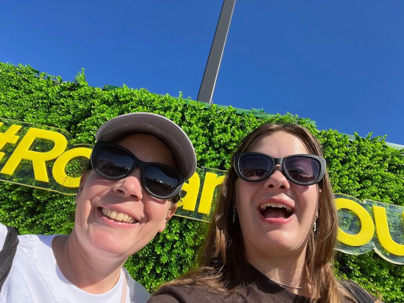 Theresa and Abigail Cassino smile in front of a #RowanPROUD sign at Homecoming.