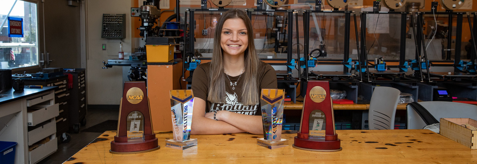 Rowan mechanical engineering student Abby smiles in front of her engineering equipment in the lab.