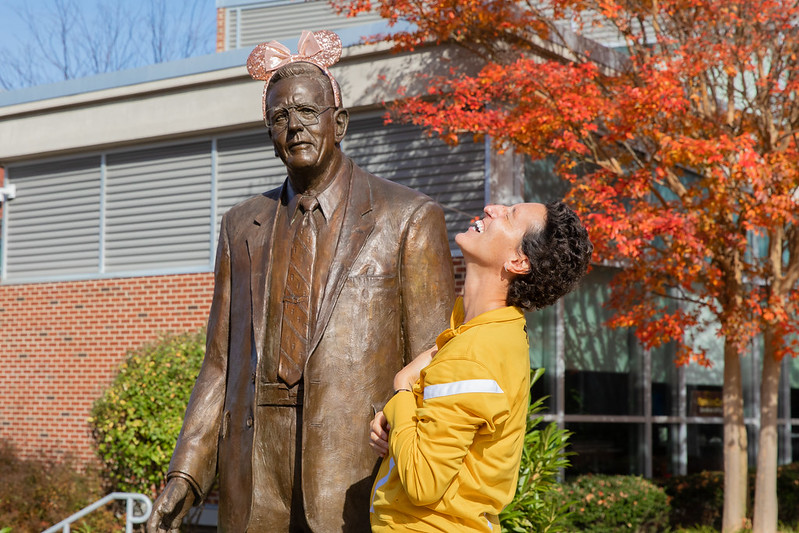 Miranda is standing next to the Henry Rowan statue and smiling.