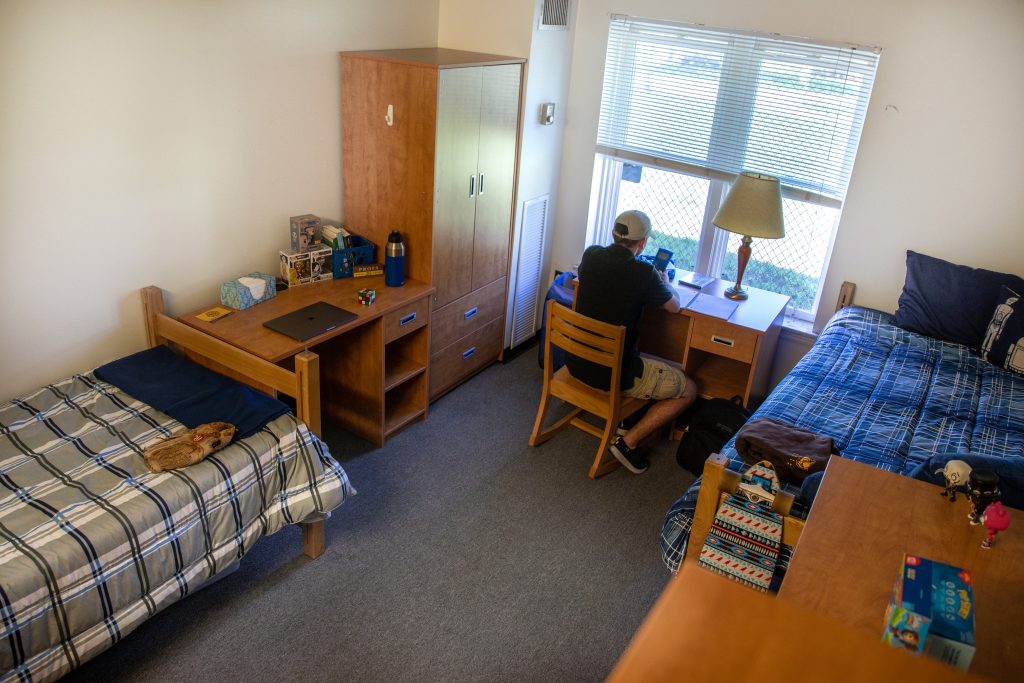 Residential hall dorm with blue decorations and 2 beds.