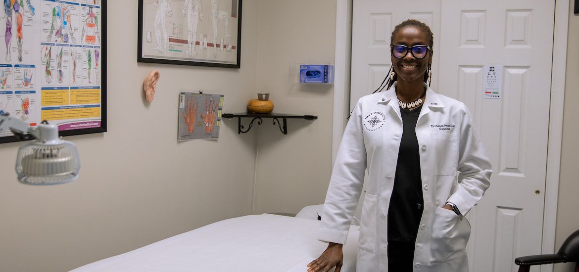 Dr. Penick stands in her office wearing a white physician coat.