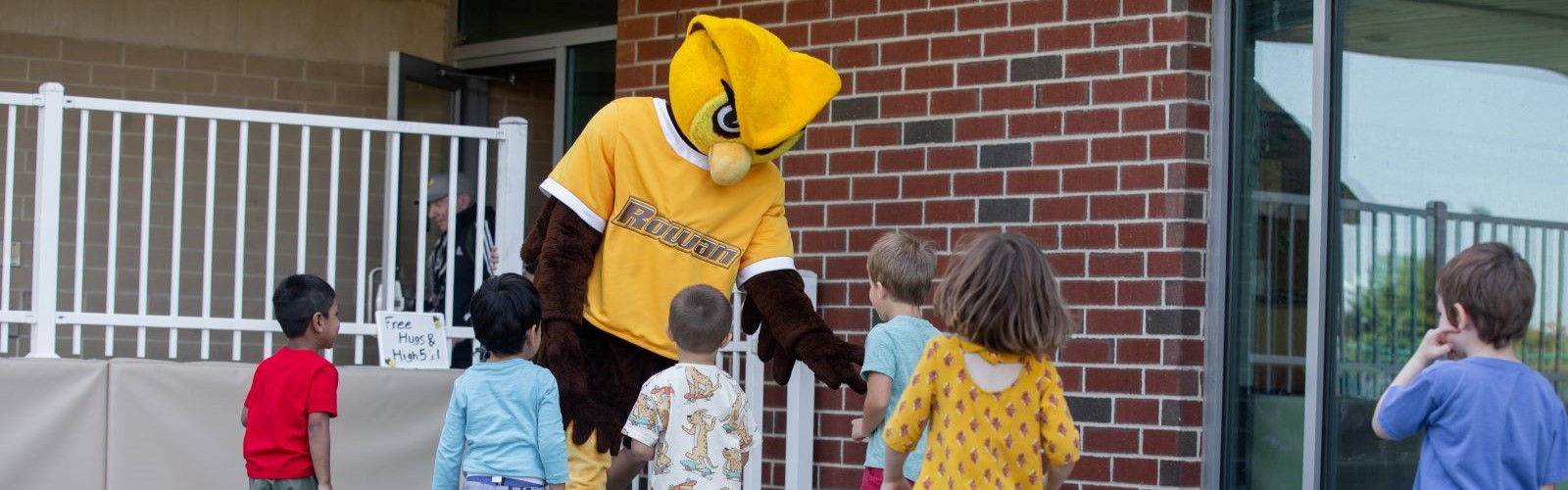 Prof mascot playing with kids.