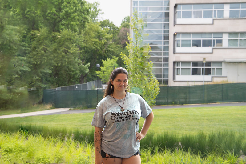 Sophia stands on campus with the wetlands surrounding Engineering Hall around her. 
