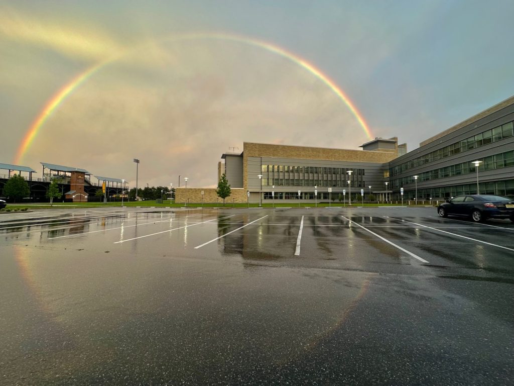 A full half-circle rainbow over Engineering Hall at Rowan University. 