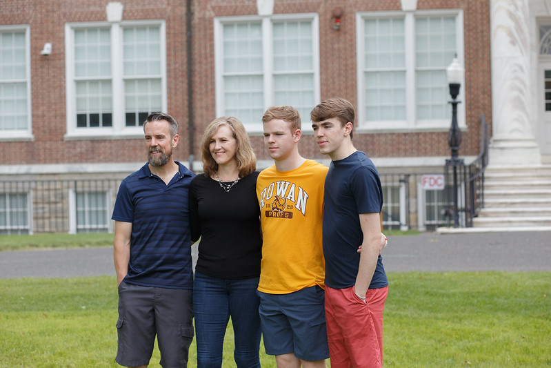 A family of four, with a new Rowan Prof wearing a Rowan t-shirt standing in the middle. 