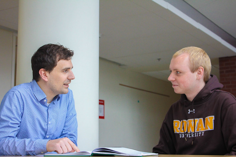 A Rowan student sits with a faculty member in a conversation. 