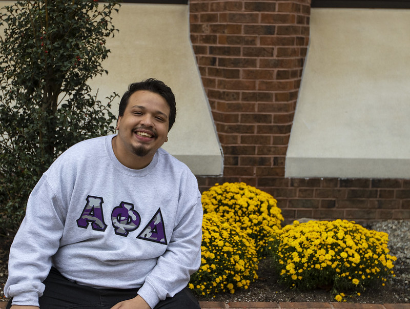 A Rowan University transfer smiles brightly in his new fraternity Greek letters on his shirt. 