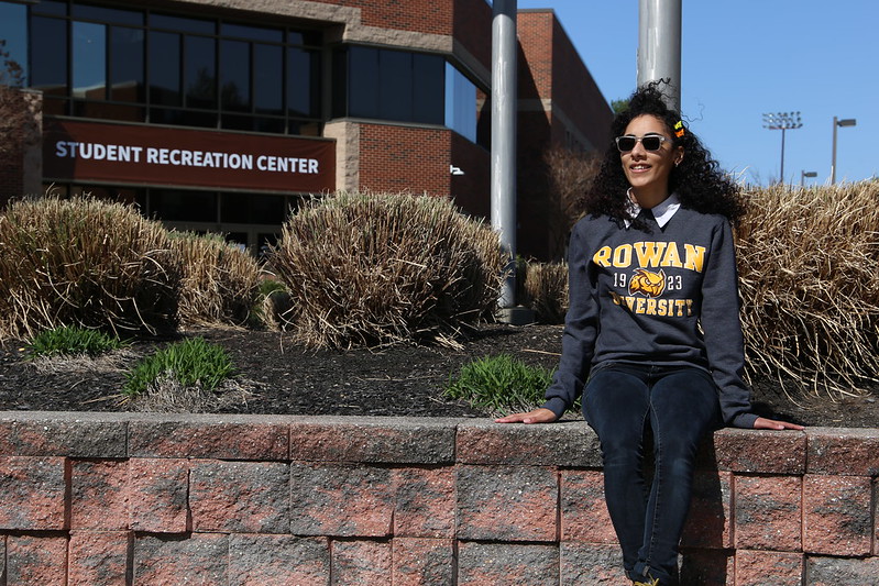 A Rowan University transfer sits outside the Rec Center wearing her new Rowan shirt. 
