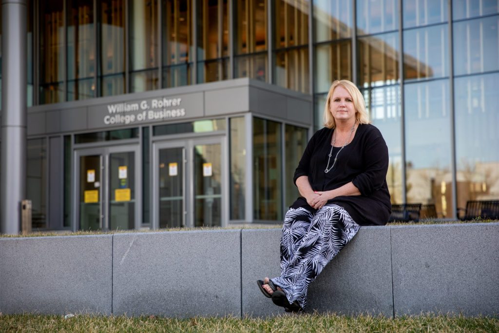 Kellie Stout sitting outside of the Rohrer College of Business.
