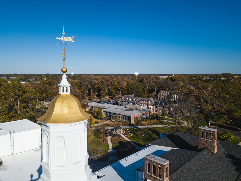 A drone view of the town of Glassboro, with the water tower in the distance and top of Bunce tower in the foreground. 