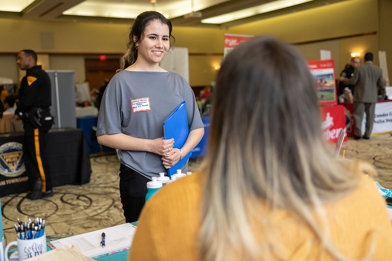 A student talking to an employer at a career fair. 