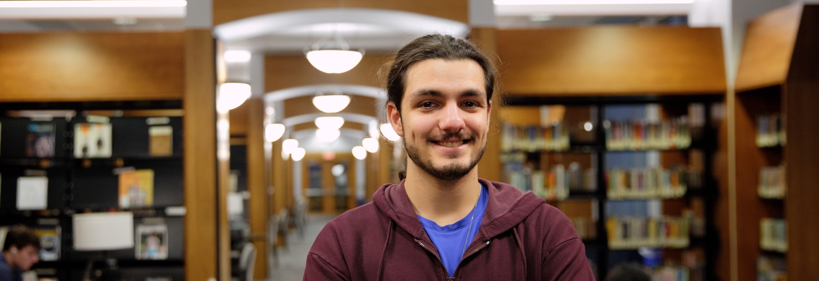 Eren stands for a portrait in the library.