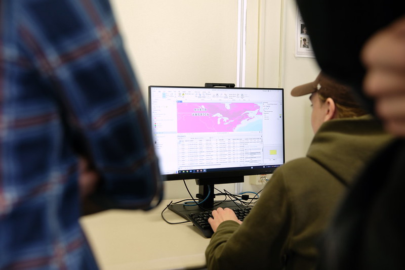 A student looks at a screen with mapping information on the monitor. 