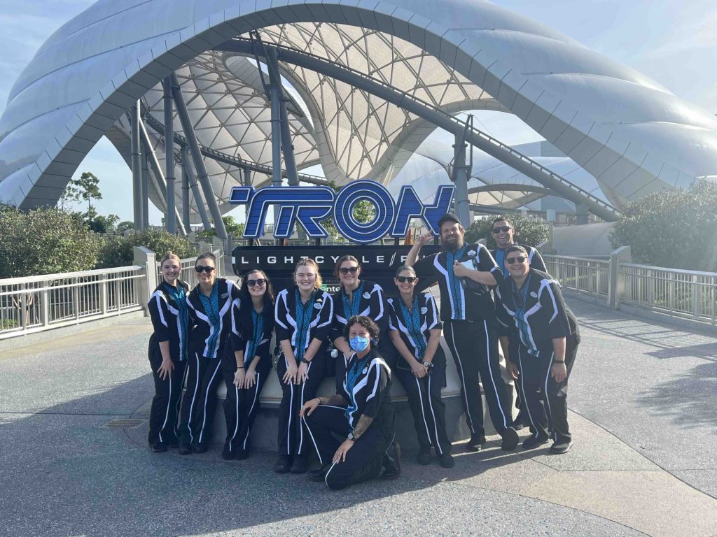 Miranda with her 9 person team outside of Tron. Miranda is wearing a mask. 