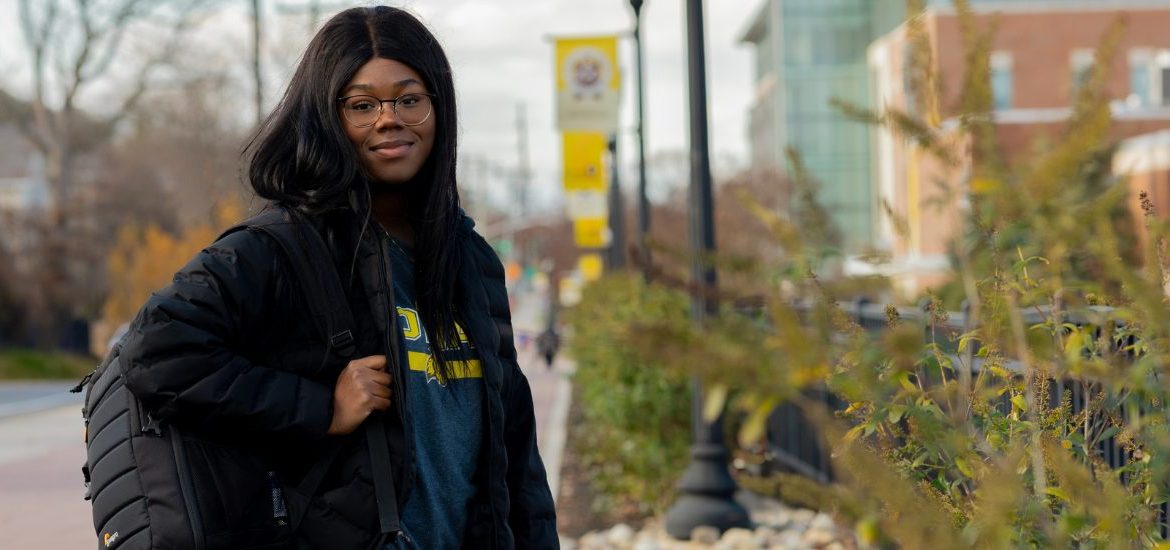 Asiya stands outside on campus on a chilly day.