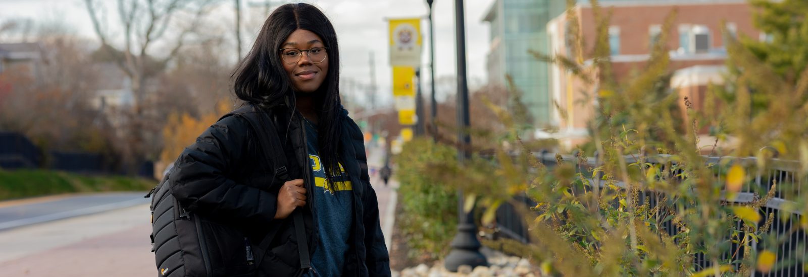 Asiya stands outside on campus on a chilly day.