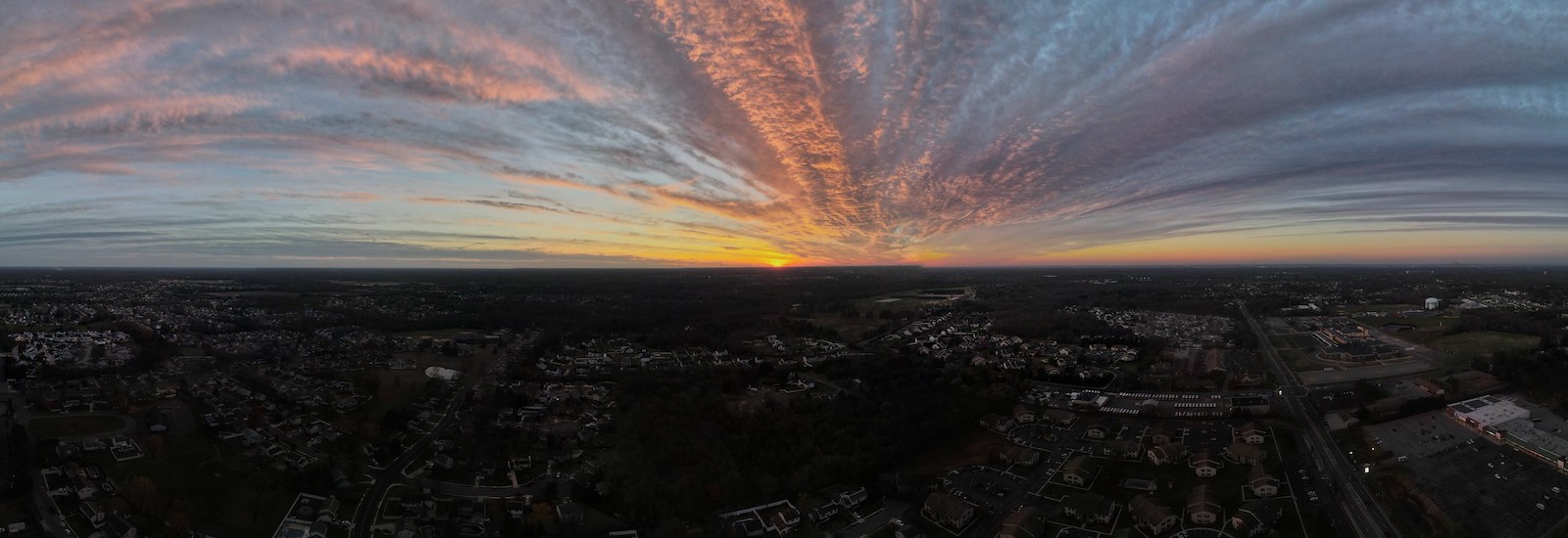 Dramtically colored sunset over the town of Glassboro, as seen from a drone.