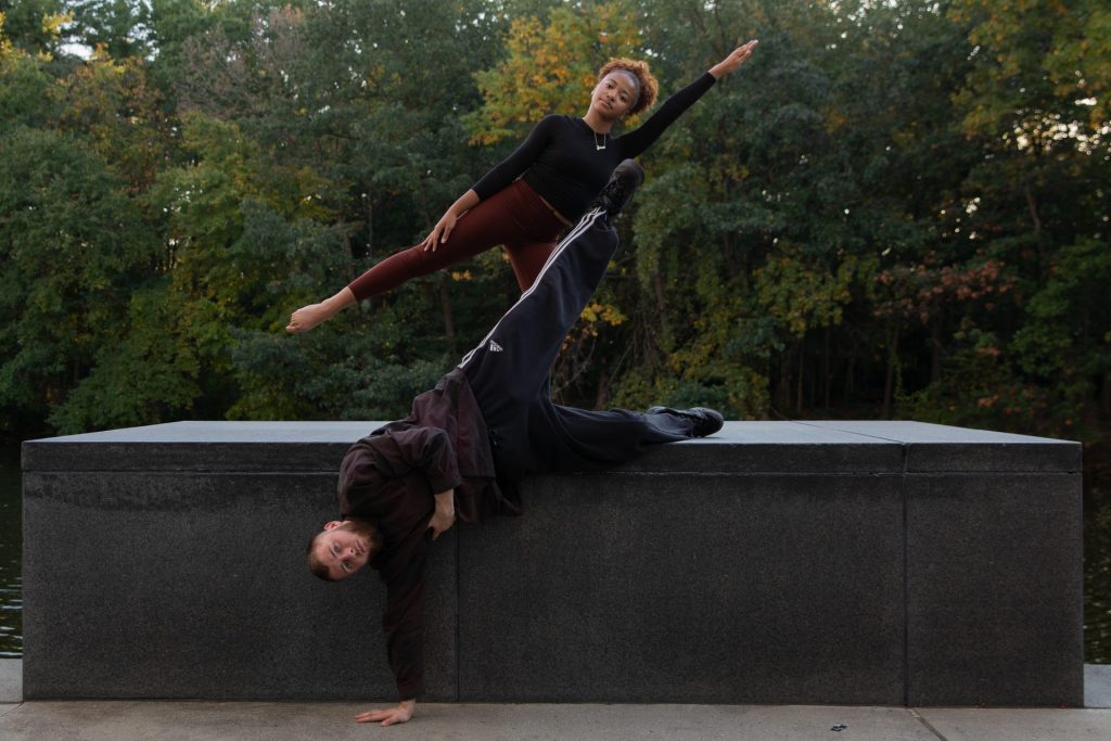 Two dancers create lines with their bodies outdoors. 