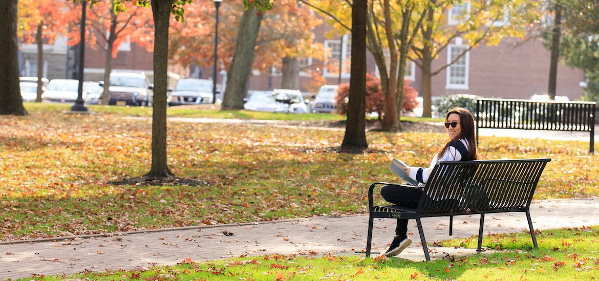 Suzie sitting on a bench on a fall day.