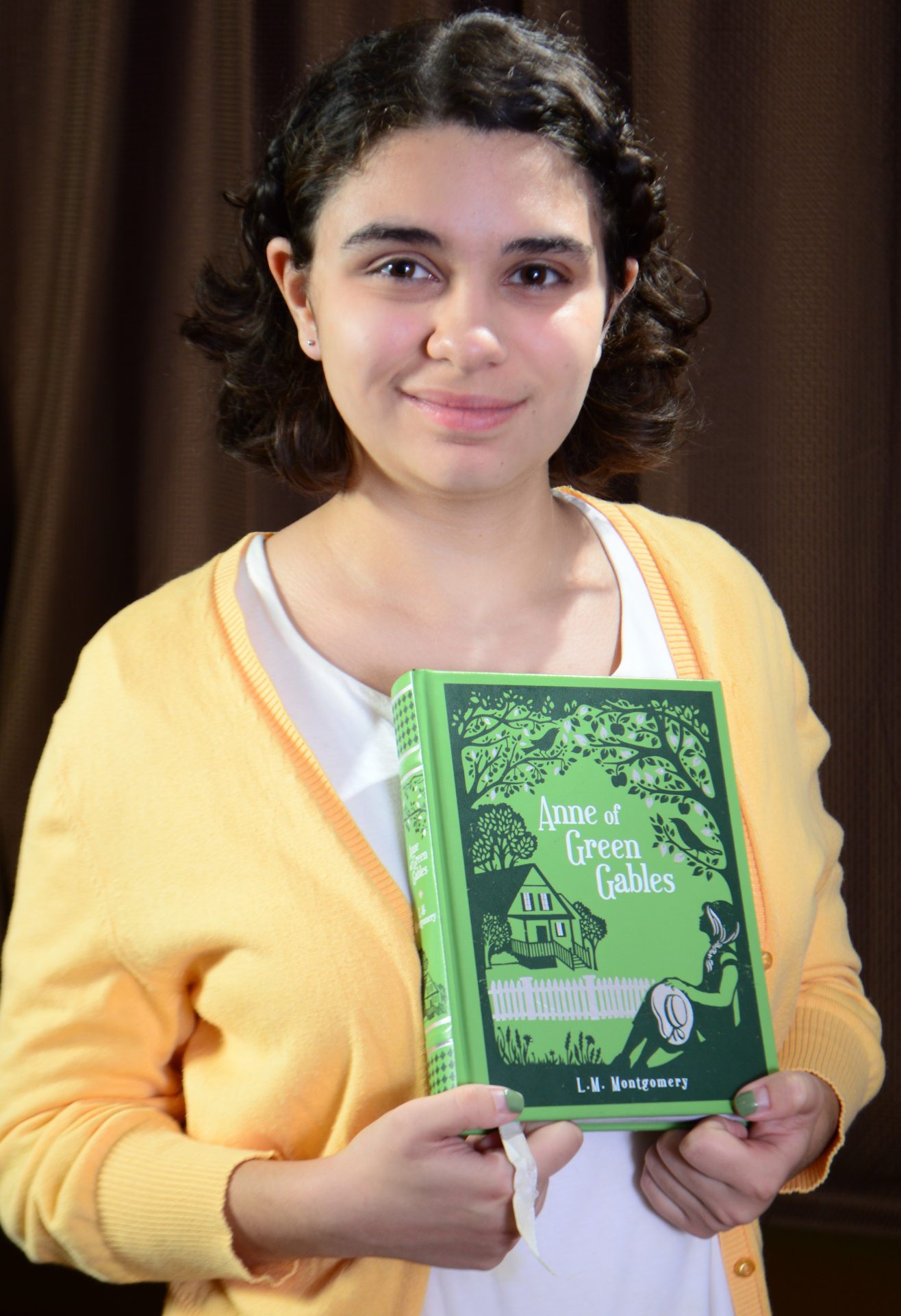 Cecilia holding Anne of Green Gables by L.M. Montgomery, 