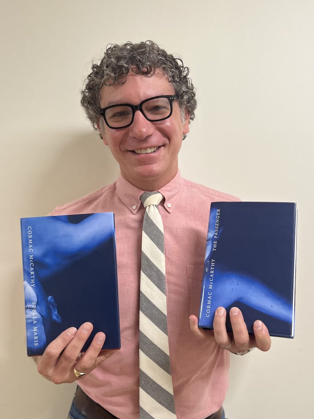 Professor Diulio holds a book in each hand. 