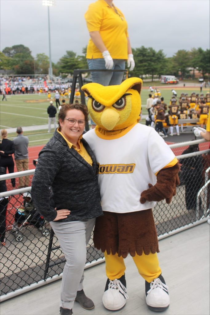 Megan Cooney stands for a posed shot with the University mascot, the Prof. 