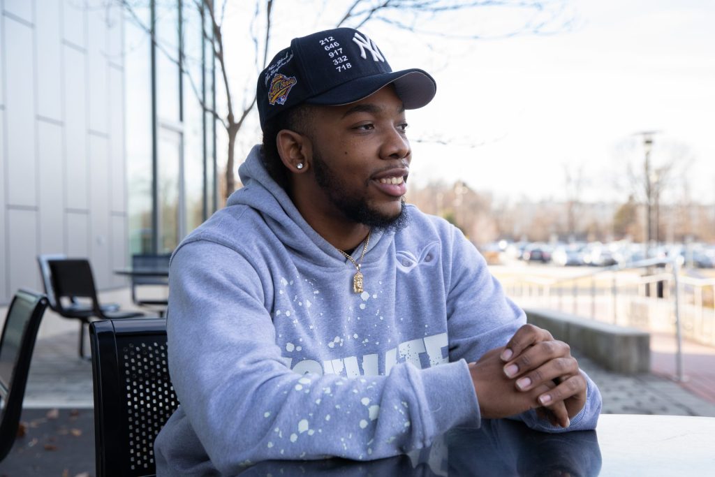 Markese Davis sitting outside the William G Rohrer College of Business building.